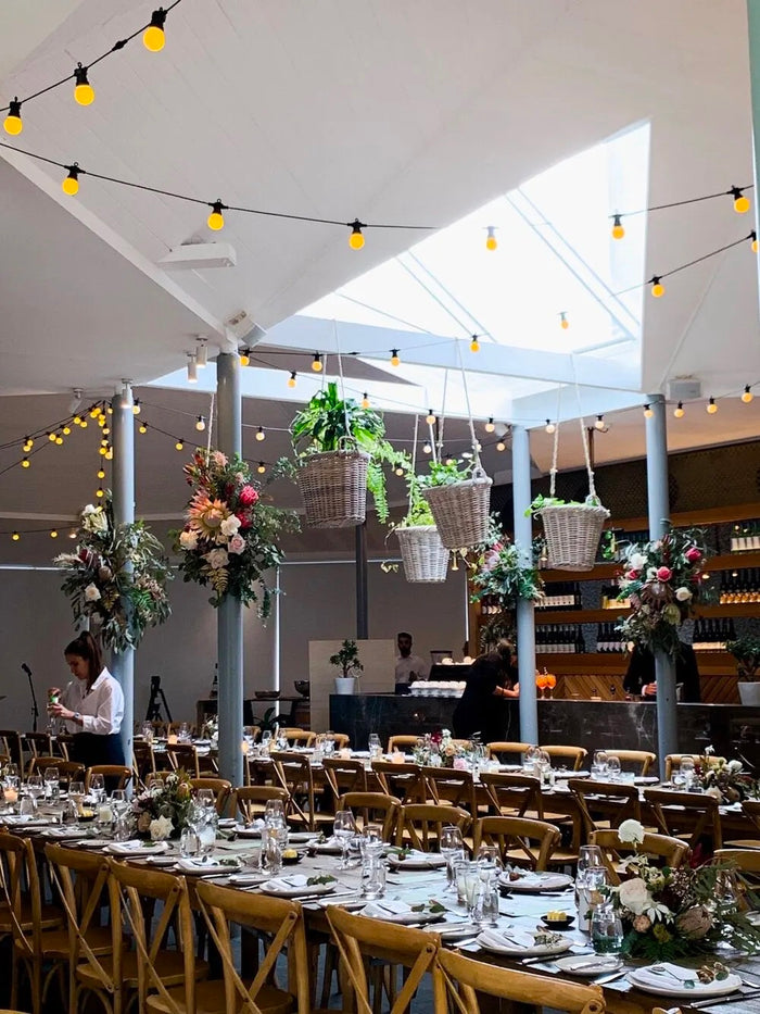 Long tables under hanging florals at Centennial Homestead