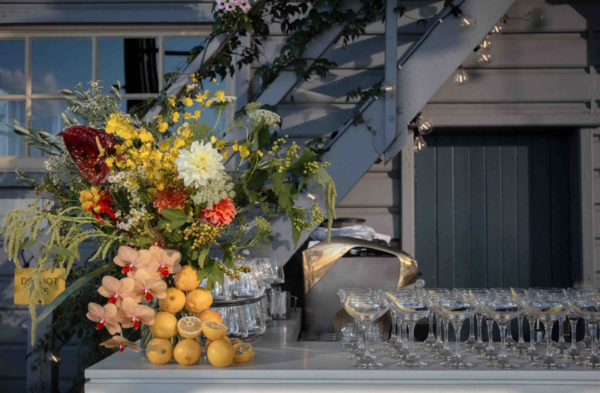 Decorative bar table setup with flowers, citrus fruits orchids for corporate event christmas party in sydney