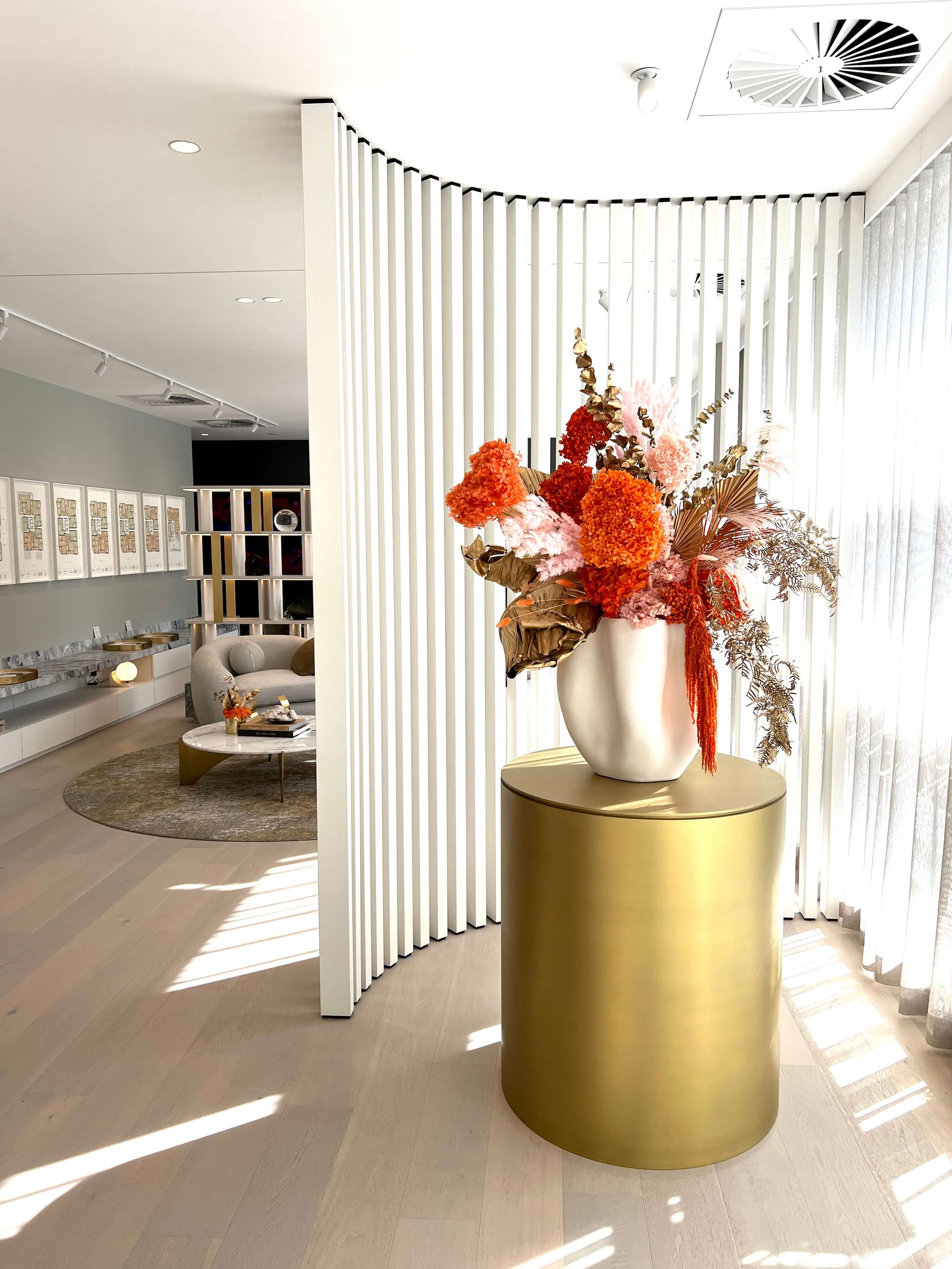 Modern interior with a gold side table and floral arrangement