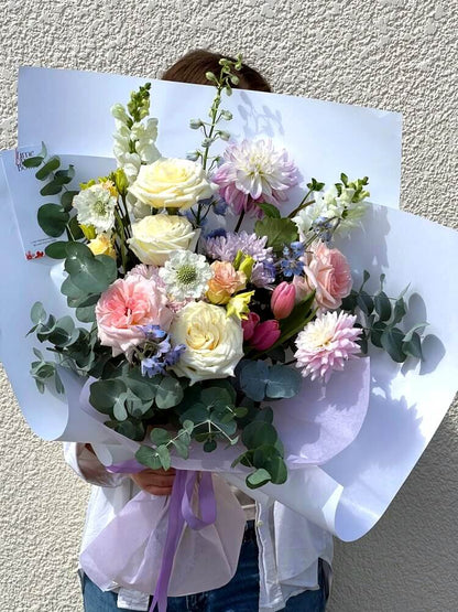 mothers day pastel soft coloured bouquet with dahlias snapdragons roses yellow and pink tulips delphinium chrysanthemum