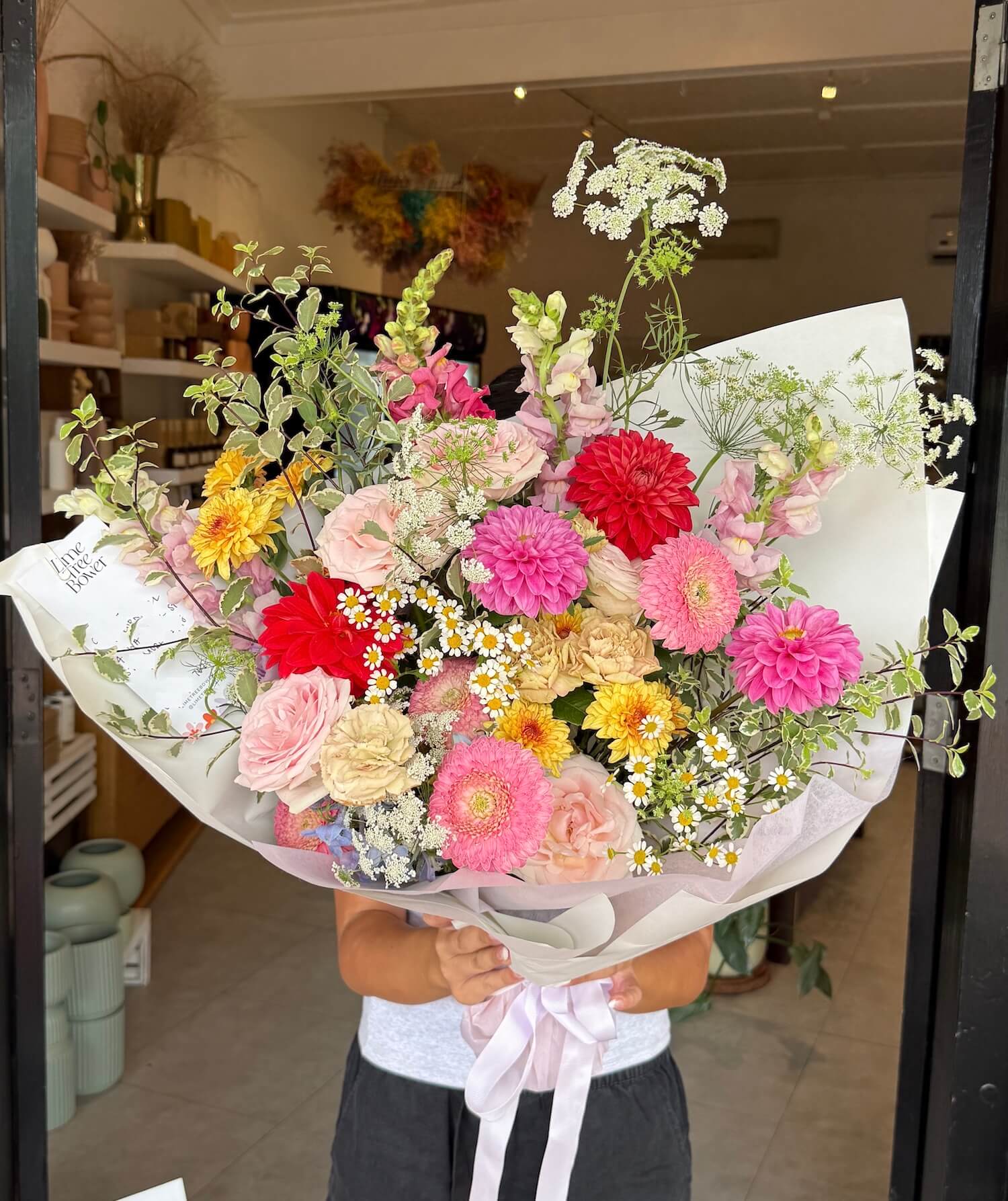 Bouquet of colorful flowers held by a person in a store setting